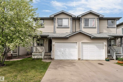 Multi-level residence featuring light-colored siding, a pitched shingle roof, and multiple windows - 3032 31 Avenue Nw, Edmonton, AB - Outdoor With Facade