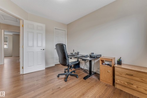 Wood-finish flooring throughout, white paneled interior doors, and neutral wall paint - 3032 31 Avenue Nw, Edmonton, AB - Indoor Photo Showing Office