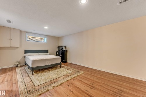 Wood-finish flooring, recessed lighting, and wall-mounted cabinetry with double doors - 3032 31 Avenue Nw, Edmonton, AB - Indoor