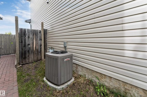 Exterior vinyl siding with a foundation, brick paver walkway, and a wooden fence - 3032 31 Avenue Nw, Edmonton, AB - Outdoor With Exterior