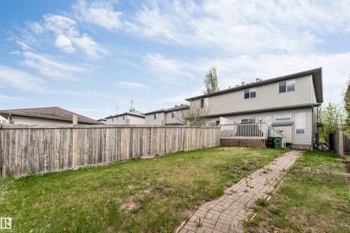 Rear exterior featuring a wood deck, brick pathway, and fenced yard - 3032 31 Avenue Nw, Edmonton, AB - Outdoor