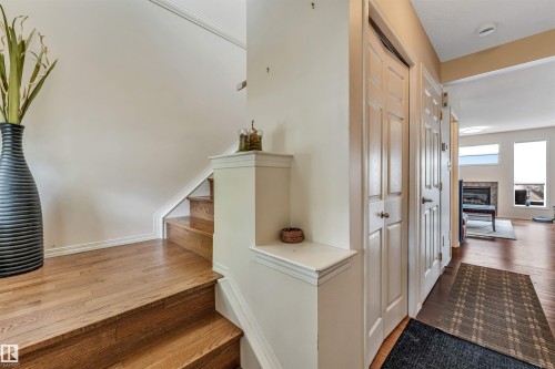 Hardwood flooring, painted interior doors, and a built-in fireplace with a stone surround - 3032 31 Avenue Nw, Edmonton, AB - Indoor Photo Showing Other Room