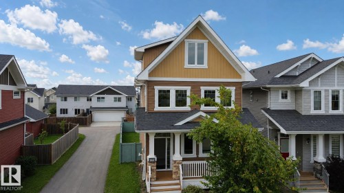 Contemporary exterior featuring multiple window styles, a covered front porch with stone pillars, and a dormer window - 16464 15 Avenue Sw, Edmonton, AB - Outdoor With Facade