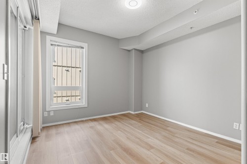 Light-toned wood-finish flooring, light gray wall paint, and recessed ceiling lighting - #404 11103 84 Av Nw, Edmonton, AB - Indoor Photo Showing Other Room