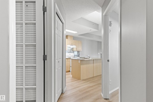 Open kitchen featuring light wood-finish cabinetry, granite-style countertops, and a double basin sink - #404 11103 84 Av Nw, Edmonton, AB - Indoor