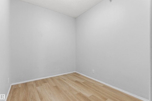 Light wood-finish flooring and light gray walls - #404 11103 84 Av Nw, Edmonton, AB - Indoor Photo Showing Other Room