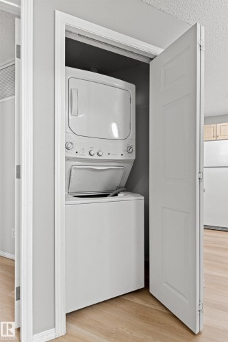 Dedicated laundry closet with a stacked washer and dryer unit - #404 11103 84 Av Nw, Edmonton, AB - Indoor Photo Showing Laundry Room