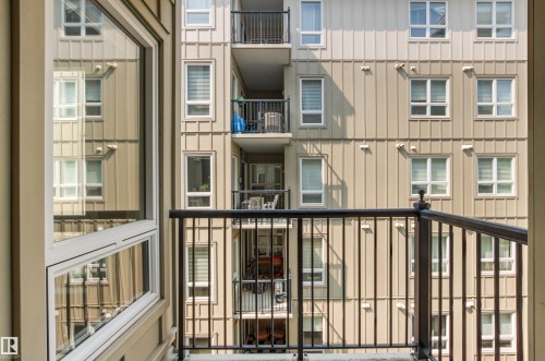 Balcony with black metal railing and a large window with white framing - #404 11103 84 Av Nw, Edmonton, AB - Outdoor With Balcony With Exterior