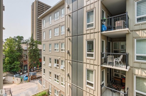 Multi-level residential building featuring private balconies with black metal railings, multiple windows, and a mix of vertical and horizontal siding - #404 11103 84 Av Nw, Edmonton, AB - Outdoor With Balcony
