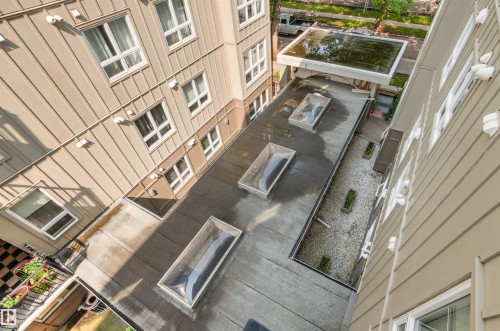 Multiple skylights, flat roof, light-colored vertical siding, window fenestration - #404 11103 84 Av Nw, Edmonton, AB - 
