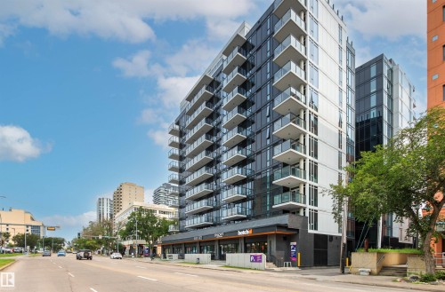 Modern high-rise residential building featuring extensive glazing, private balconies with glass railings, and a ground-floor commercial space - #404 11103 84 Av Nw, Edmonton, AB - Outdoor With Balcony With Facade