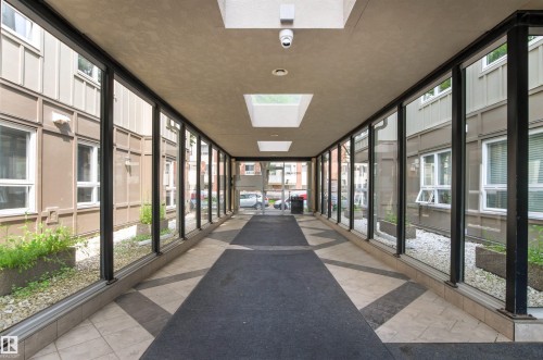 Enclosed walkway featuring full-height windows, skylights, and a tiled floor with an integrated runner - #404 11103 84 Av Nw, Edmonton, AB - Indoor Photo Showing Other Room