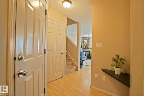 Wood-finish flooring throughout, light-colored walls, and paneled interior doors - #42 4350 23 St Nw, Edmonton, AB - Indoor Photo Showing Other Room