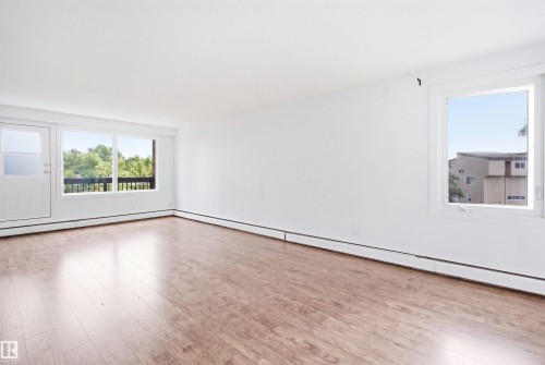 Wood-finish flooring, white walls, white trim, and multiple windows - 7825 159 Street Nw, Edmonton, AB - Indoor Photo Showing Other Room
