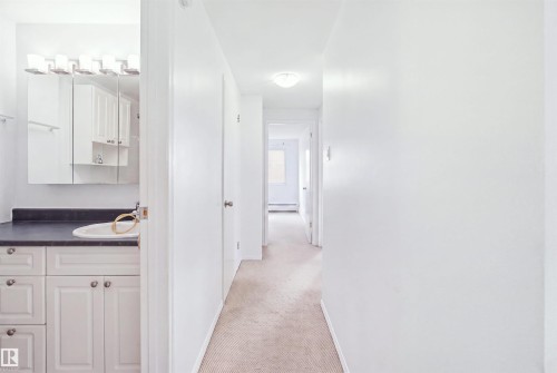 Vanity with an integrated sink, dark countertop, and white cabinetry - 7825 159 Street Nw, Edmonton, AB - Indoor Photo Showing Other Room