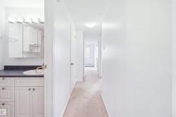 Vanity with an integrated sink, dark countertop, and white cabinetry - 