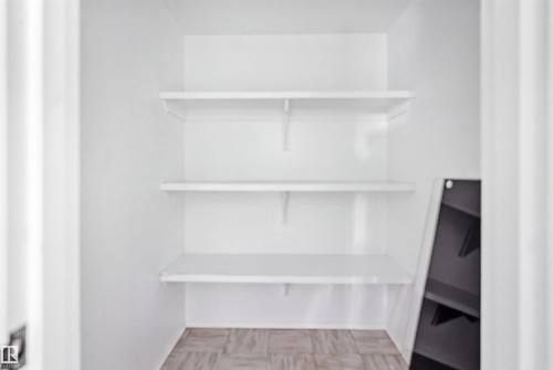 White shelving system with three levels, light-toned patterned flooring - 7825 159 Street Nw, Edmonton, AB - Indoor With Storage