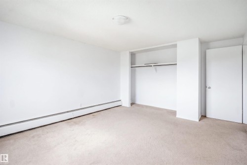 Neutral-toned carpeting, white walls, and a built-in closet with shelving and hanging rod - 7825 159 Street Nw, Edmonton, AB - Indoor Photo Showing Other Room