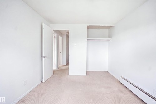 Carpeted flooring, white walls, and an open closet with shelving and hanging rod - 7825 159 Street Nw, Edmonton, AB - Indoor Photo Showing Other Room