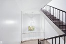 Stairwell featuring metal railings, pendant lighting, and carpeted stairs - 201-7825 159 Street Nw, Edmonton, AB  - Indoor Photo Showing Other Room 