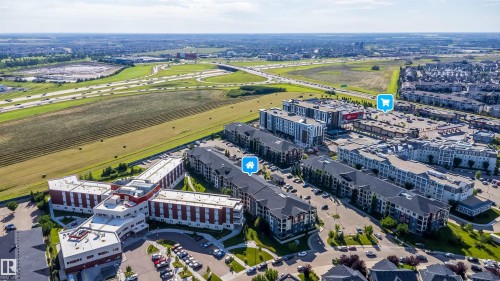 Aerial perspective showcasing a residential development with multiple buildings and integrated parking - #315 5816 Mullen Pl Nw, Edmonton, AB - Outdoor With View