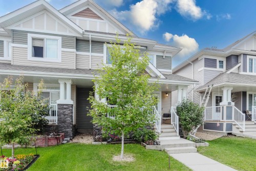 Two-story home with light-colored siding and stone accents - 124 Cy Becker Boulevard Nw, Edmonton, AB - Outdoor With Facade