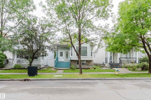 Light blue siding exterior with a stone foundation, featuring a prominent front porch with teal-painted stairs and white railings - 1694 Tompkins Wynd Nw, Edmonton, AB - Outdoor With Facade