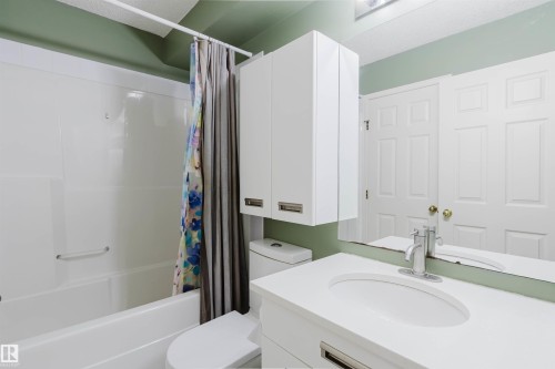 Bathroom featuring a white vanity with integrated sink, chrome faucet, and a large mirror - 1694 Tompkins Wynd Nw, Edmonton, AB - Indoor Photo Showing Bathroom
