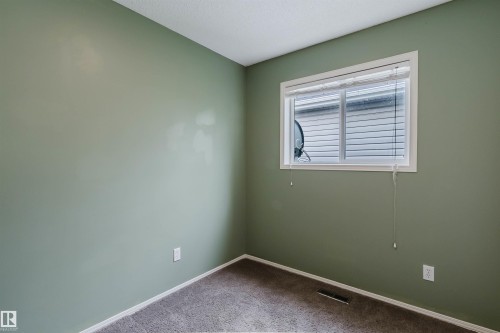Room featuring light green walls, a single window with white trim, and neutral carpet flooring - 1694 Tompkins Wynd Nw, Edmonton, AB - Indoor Photo Showing Other Room