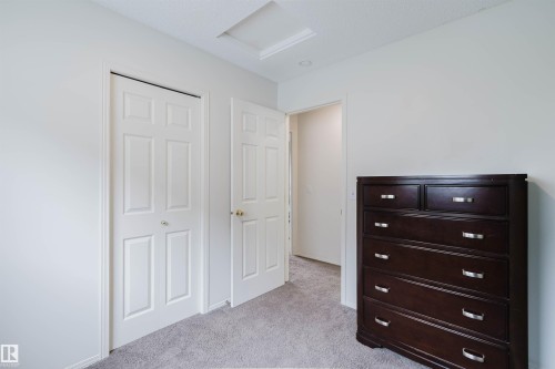 White paneled interior doors, light gray carpet flooring, and white baseboards - 1694 Tompkins Wynd Nw, Edmonton, AB - Indoor