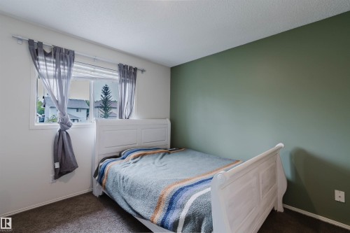 Carpeted room with a green accent wall and white trim - 1694 Tompkins Wynd Nw, Edmonton, AB - Indoor Photo Showing Bedroom