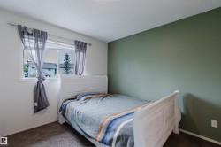 Carpeted room with a green accent wall and white trim - 
