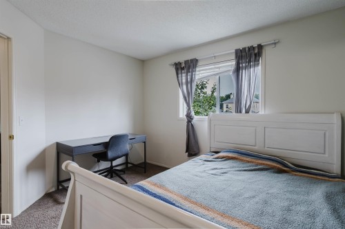 Carpeted room featuring light-colored walls and a window with white trim - 1694 Tompkins Wynd Nw, Edmonton, AB - Indoor Photo Showing Bedroom
