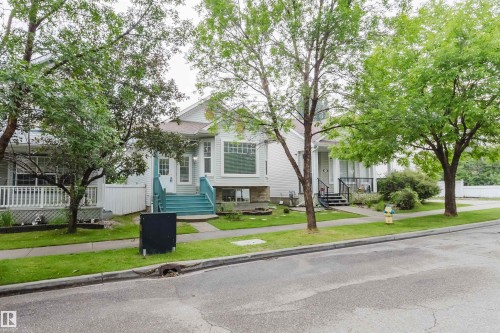 Light-colored siding exterior featuring a prominent bay window and an inviting front entrance with teal-painted steps - 1694 Tompkins Wynd Nw, Edmonton, AB - Outdoor With Facade