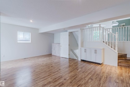 Spacious lower-level area featuring wood-finish flooring, white walls, and recessed lighting - 1694 Tompkins Wynd Nw, Edmonton, AB - Indoor
