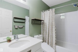 Bathroom featuring a single vanity with an integrated sink, polished chrome faucet, and a large wall mirror - 