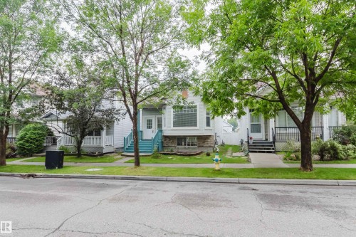 White exterior with stone detailing and a prominent bay window - 1694 Tompkins Wynd Nw, Edmonton, AB - Outdoor With Facade
