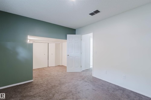 Room featuring wall-to-wall carpeting, two-tone painted walls, and a white interior door - 1694 Tompkins Wynd Nw, Edmonton, AB - Indoor Photo Showing Other Room
