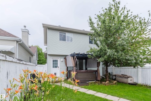 Fenced backyard featuring a walkway, a mature tree, and established plantings - 1694 Tompkins Wynd Nw, Edmonton, AB - Outdoor