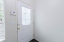 White paneled entry door with an upper window featuring grid inserts and brass hardware - 1694 Tompkins Wynd Nw, Edmonton, AB  - Indoor Photo Showing Other Room 