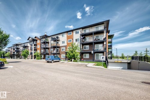 Multi-story building featuring private balconies, an underground parking entrance, and exterior cladding in varying tones - #322 148 Ebbers Bv Nw, Edmonton, AB - Outdoor With Balcony With Facade