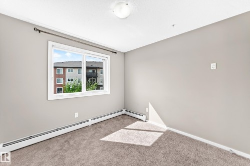 Carpeted room with neutral wall paint and a single window - #322 148 Ebbers Bv Nw, Edmonton, AB - Indoor Photo Showing Other Room