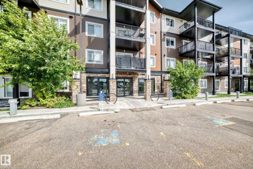 Multi-story building with a multi-tone exterior, featuring stone veneer accents and dark-framed windows - #322 148 Ebbers Bv Nw, Edmonton, AB - Outdoor With Balcony With Facade