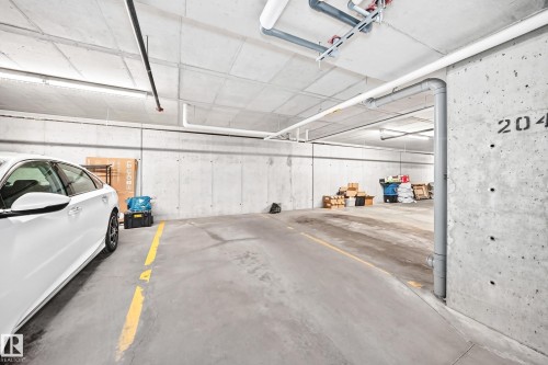 Concrete garage with clearly marked parking space - #322 148 Ebbers Bv Nw, Edmonton, AB - Indoor Photo Showing Garage