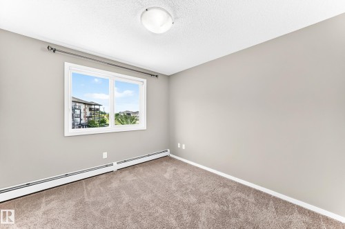 Neutral paint finish, white trim, wall-to-wall carpeting, and a flush mount ceiling light - #322 148 Ebbers Bv Nw, Edmonton, AB - Indoor Photo Showing Other Room