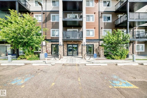 Multi-level building with stone and siding exterior, featuring multiple balconies with black railings - #322 148 Ebbers Bv Nw, Edmonton, AB - Outdoor With Balcony