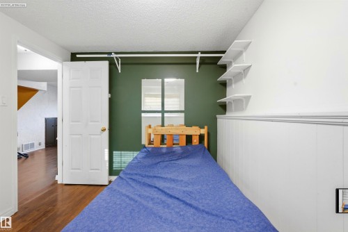 Room featuring a paneled interior door, wood-finish flooring, and a window - 13604 90A Street Nw, Edmonton, AB - Indoor Photo Showing Bedroom