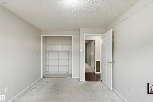 Built-in shelving, paneled door, and carpeted flooring - 13604 90A Street Nw, Edmonton, AB - Indoor Photo Showing Other Room