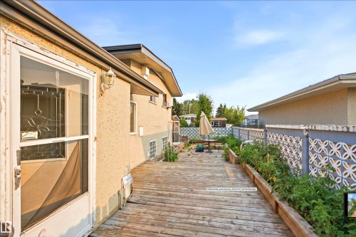 Wood-finish decking with built-in planters, stucco exterior, and decorative concrete block fencing - 13604 90A Street Nw, Edmonton, AB - Outdoor With Deck Patio Veranda With Exterior