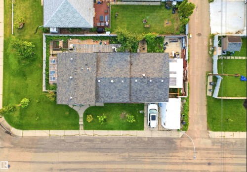 Asphalt shingle roofing over the main structure, with a front lawn and a concrete sidewalk - 13604 90A Street Nw, Edmonton, AB - 